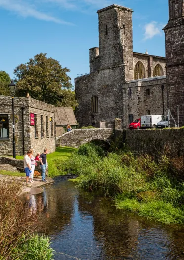 Historic buildings by a bridge over a stream.