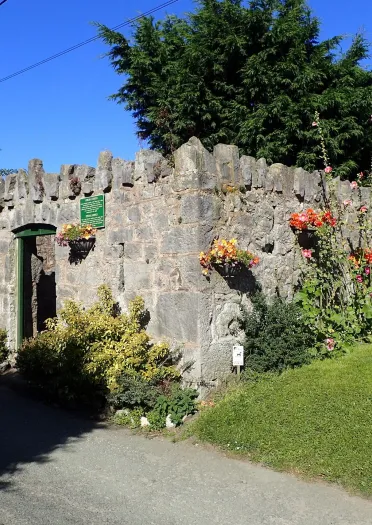 castle like walls with flowers and lawn.