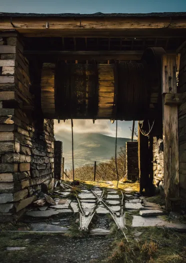 Blick durch ein stillgelegtes Windenturmhaus am oberen Ende einer Steilbahn in einem Schiefersteinbruch.