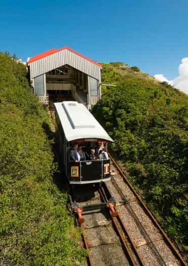 A vintage train crossing the Finacur viaduct surrounded by blue sky