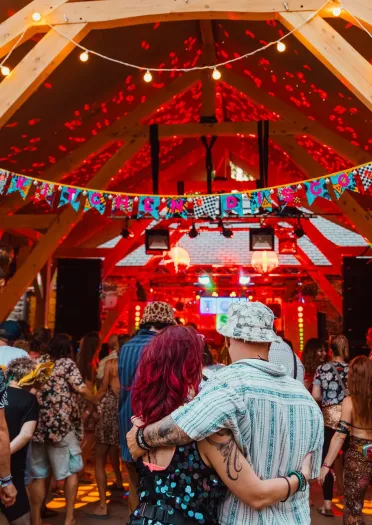 people watching performance in tent at festival.
