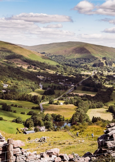 stone wall with countryside and hills in background.
