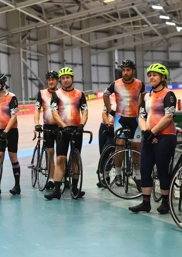 cyclists with bikes in velodrome.