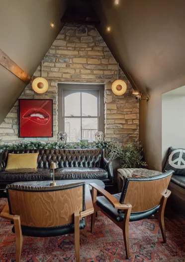 Lounge area at Hickmans featuring leather seating, exposed stonework and contemporary décor