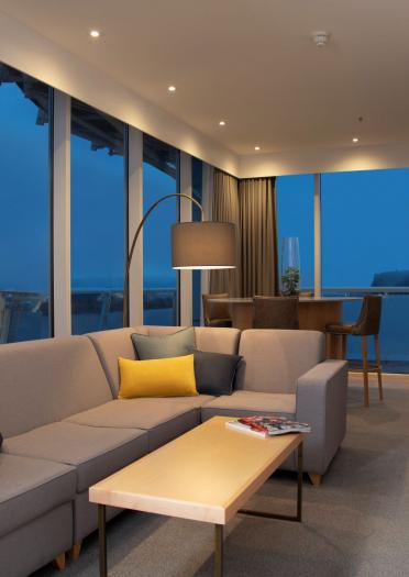 A stylish lounge area with dual aspect floor to ceiling windows overlooking the bay.