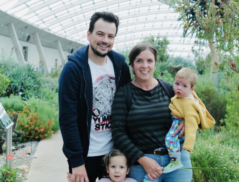 Young family posing for a photo in the glasshouse at the National Botanic Gardens