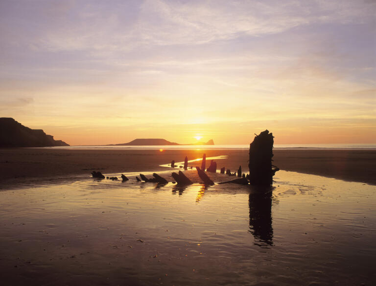 Rhossili & Worm's Head 'Helvetia' wreck beneith the sunset at Gower Peninsula.