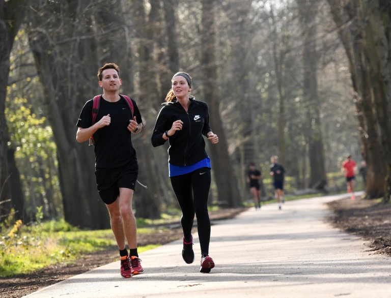 Two runners running along the Taff trail.