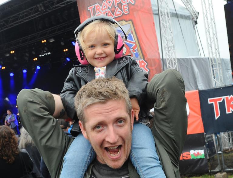 Father holding child on his shoulders at Steelhouse Festival.