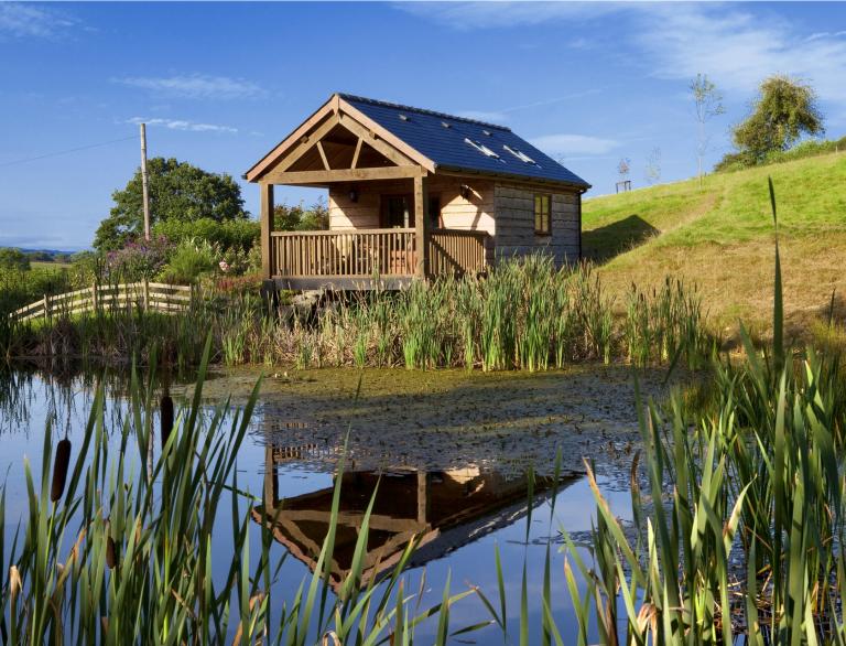 wooden building in background with pond in foreground