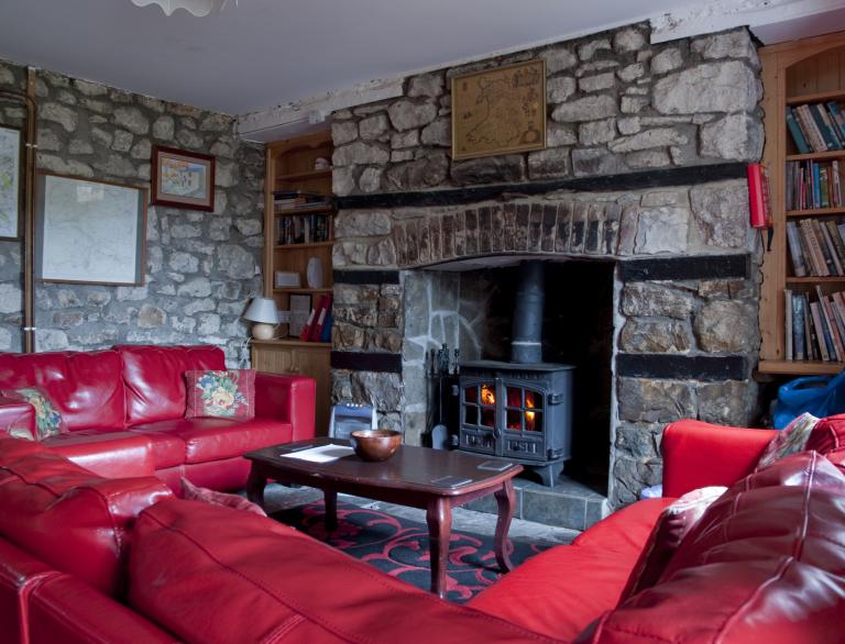 lounge with red sofas and wood stove.