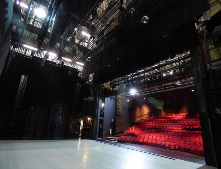 Auditorium with red seats and stage, taken from the wings