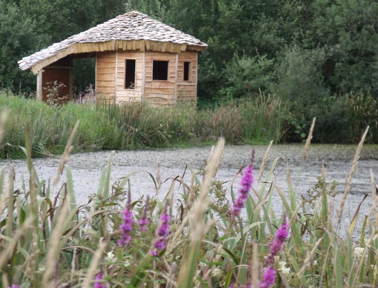 A wooden hut by a lake.