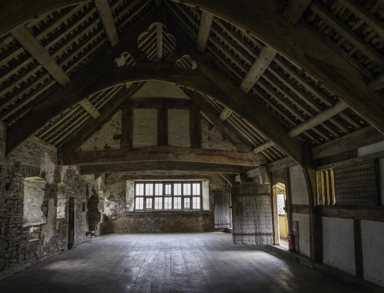 interior of historic building with wooden beams and panelled walls.