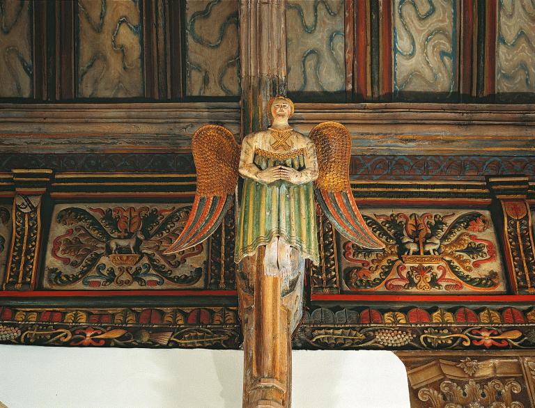 ornate angel with decorative wall and ceiling.