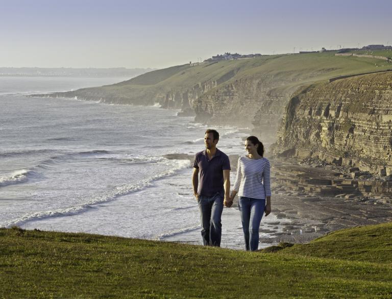 couple walking along the coast.