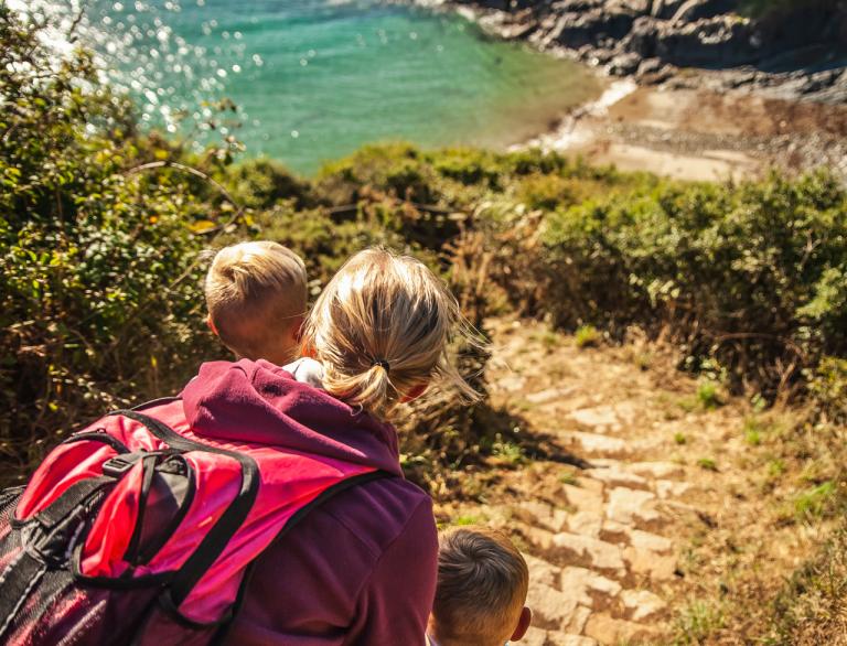 woman and two children on coast path.