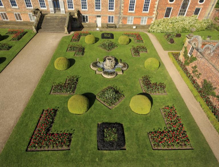 An aeriel view of the 18th century Parterre garden with a partial view of Erddig House.