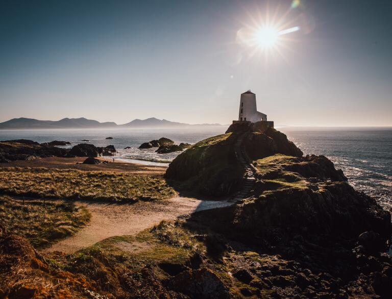 Image of the lighthouse and beach at Ynys Llanddwyn in the bright winter sun.