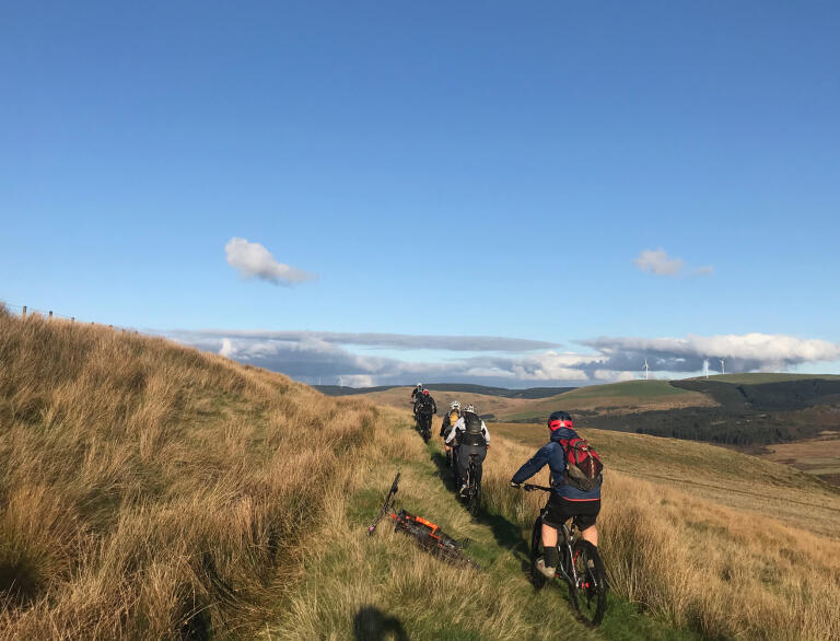 Mountain bikers on a hillside trail.