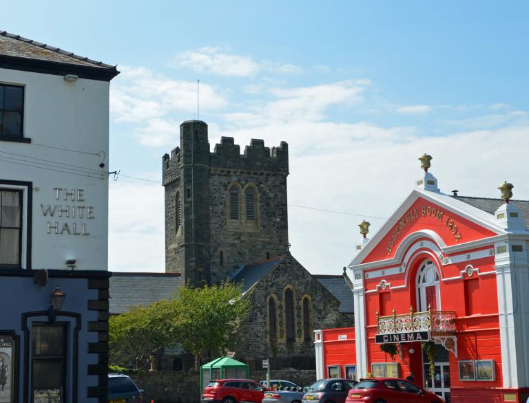 A pub, a church and a cinema on a square street.