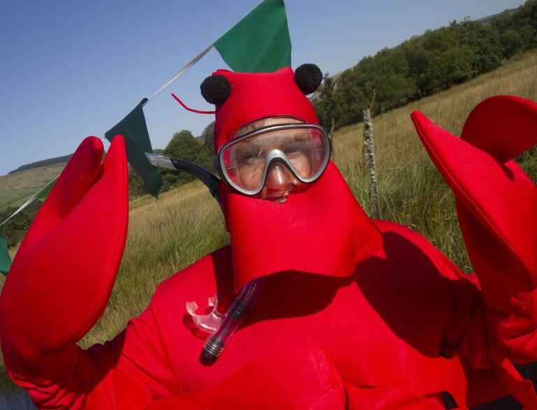 man in lobster fancy dress outfit wearing snorkel.