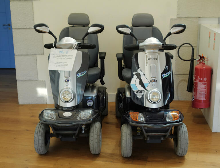 Two mobility scooters side by side.