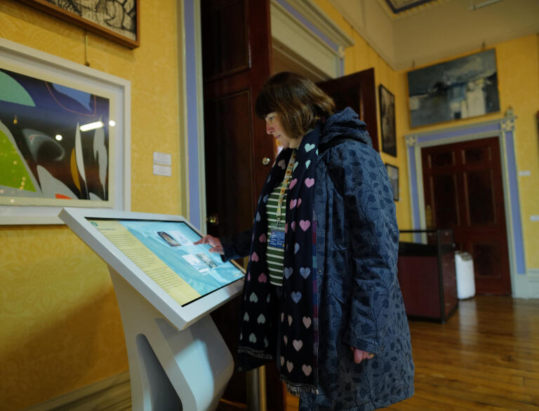 A lady looking at a digital display.