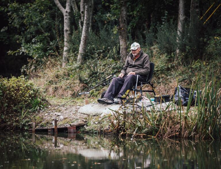 man fishing by lake.