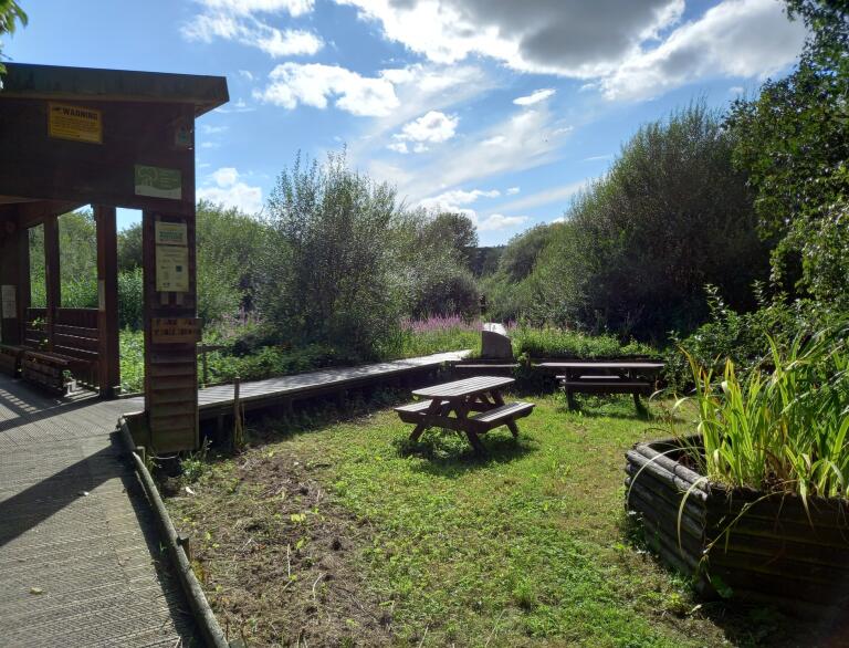 wooden benches and shelter with surrounding nature reserve.