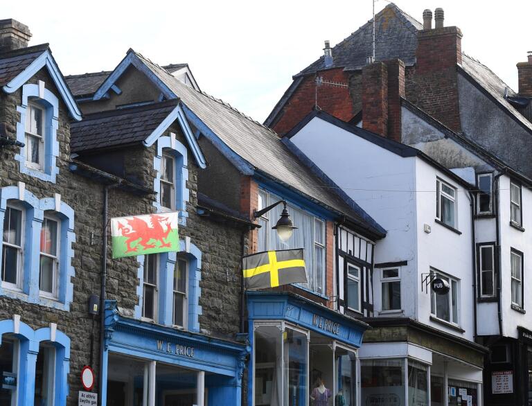 Eine Straße voller Geschäfte mit walisischen Flaggen.