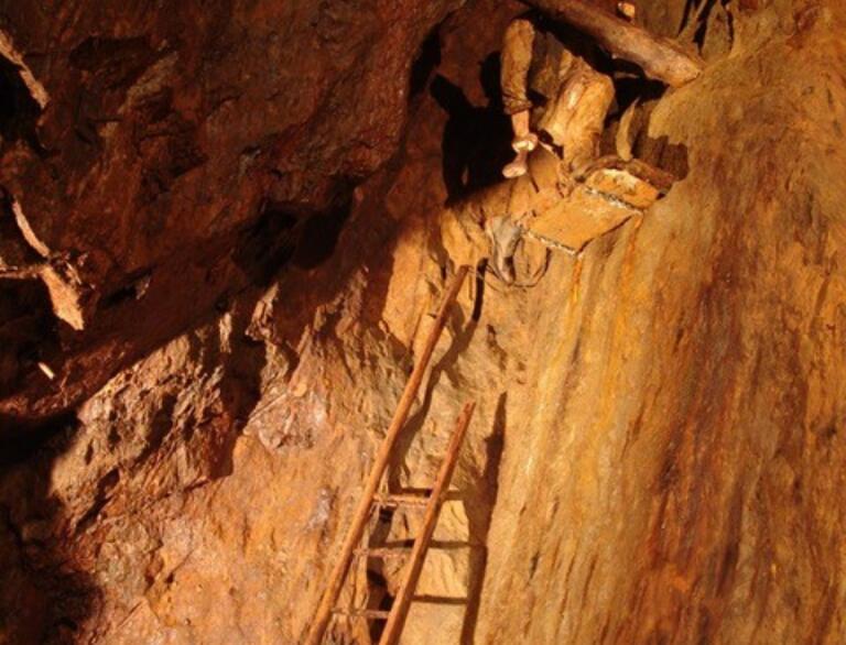 inside copper mine, with model on ladder.
