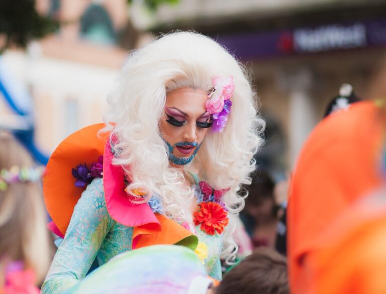 Drag queen with blond wig, false eye lashes and coloured beard