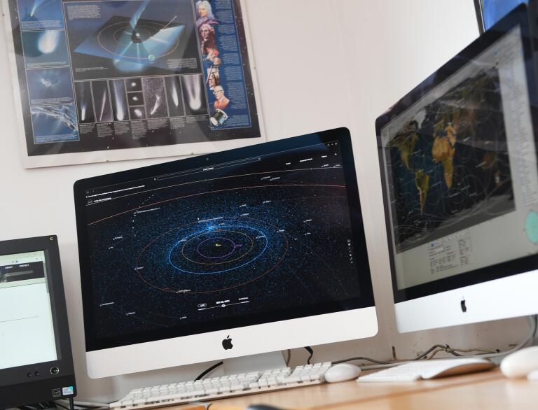 Computer monitors showing astronomical information.