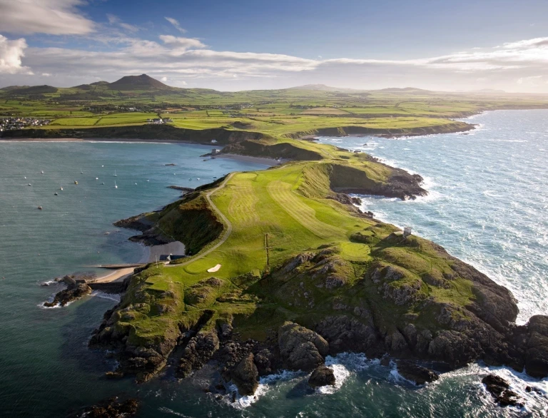 Aerial view of Nefyn golf course on a peninsula stretching out to sea