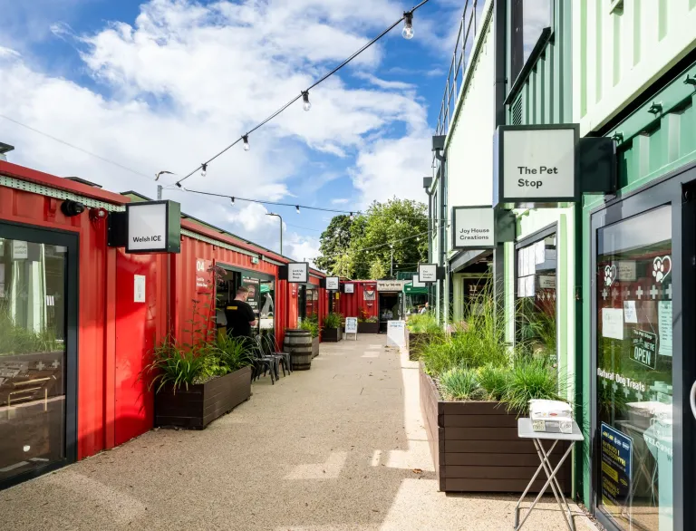 shopping centre made from shipping containers with planters.