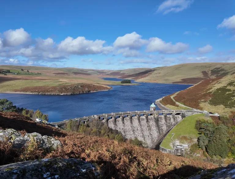 dam and reservoir on sunny day.