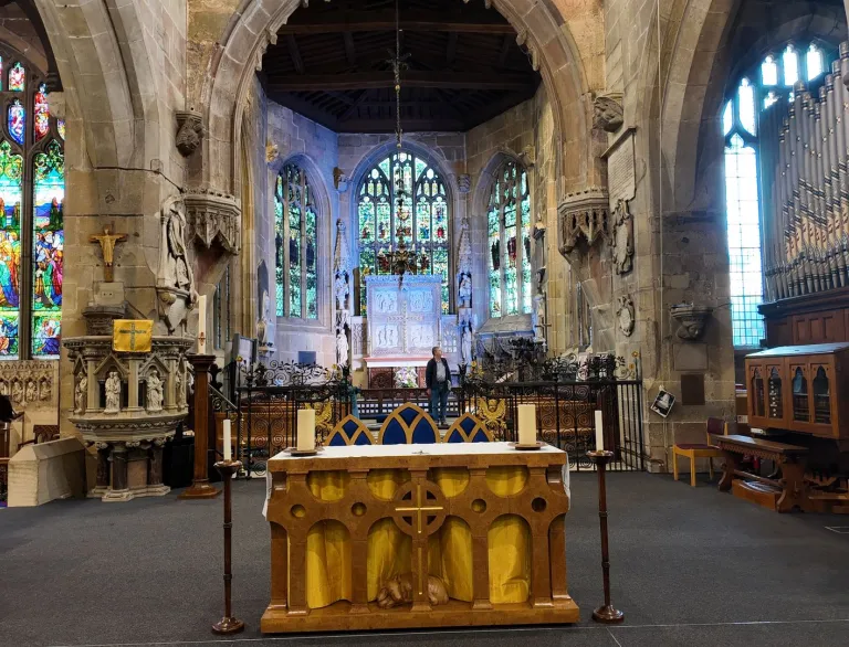 Interior of a church with alter and stained glass windows.