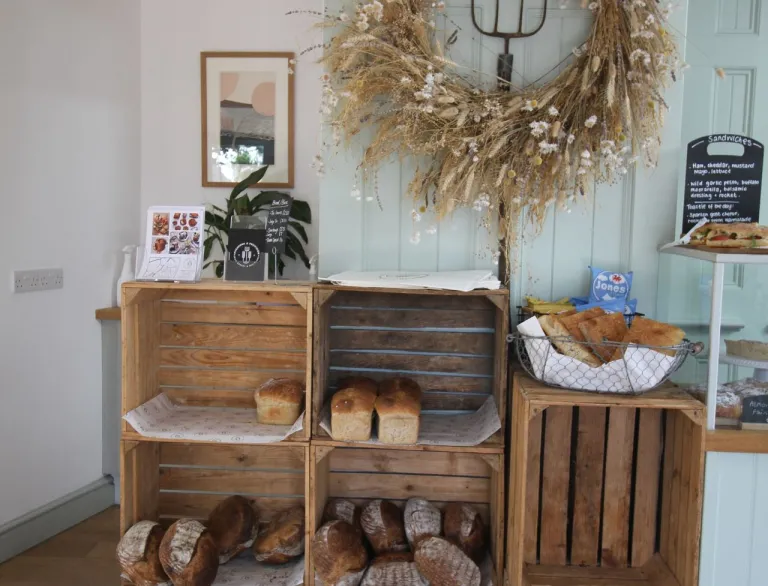 display in show with pitchfork, gold wreath and bread in wooden crates.