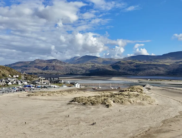 A hillside town with a harbour and huge, sandy beach.