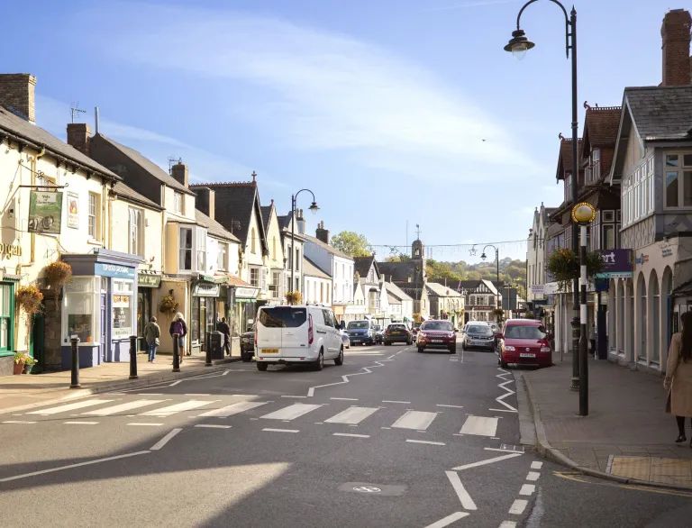 A busy high street with several shops. 