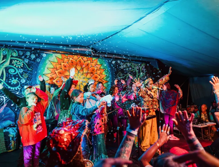 Crowds dancing to a band on stage.