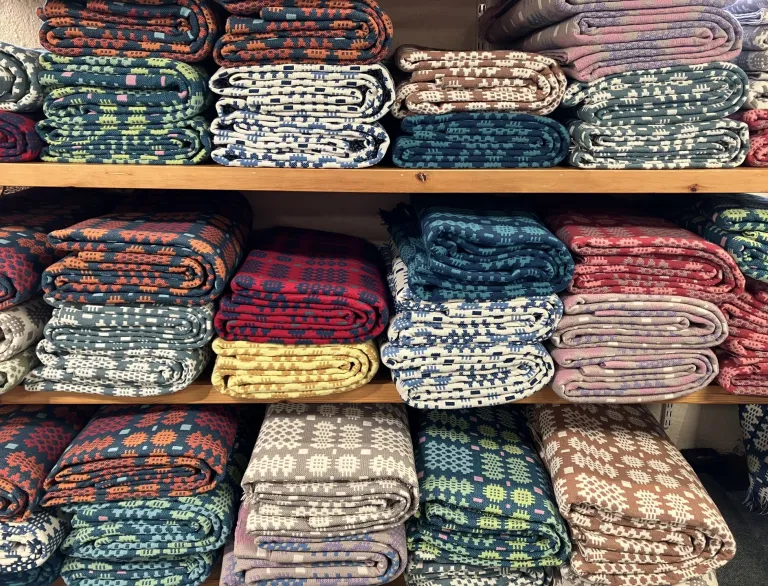 Shelves full of colourful folded Welsh blankets.