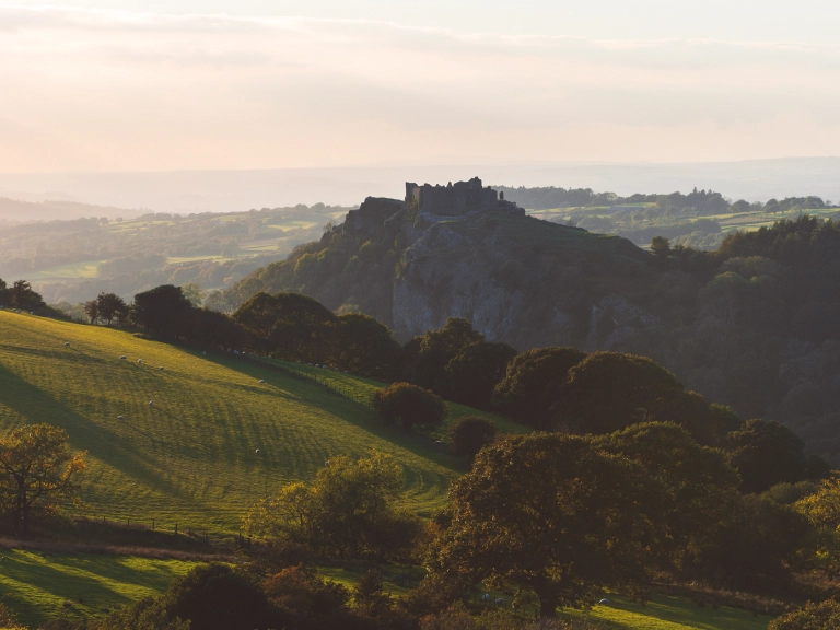 A semi-ruined castle on a hill in countryside.