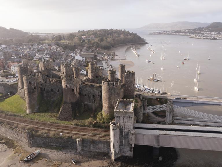 Conwy Castle and the railway line from above, with views across the bay.