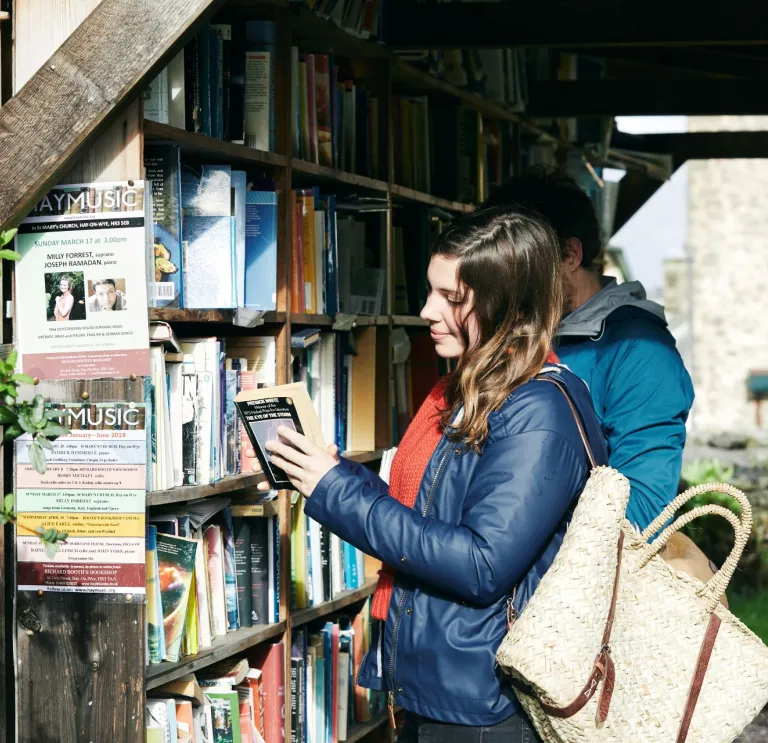 A lady looking at books in Hay-on-Wye.
