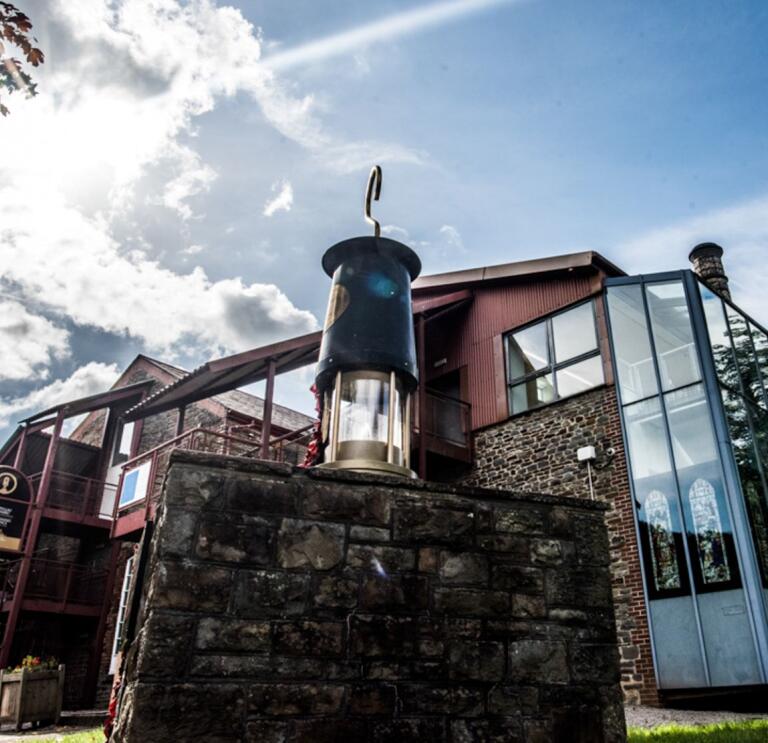 A mining lamp on a wall outside a mining visitor centre.