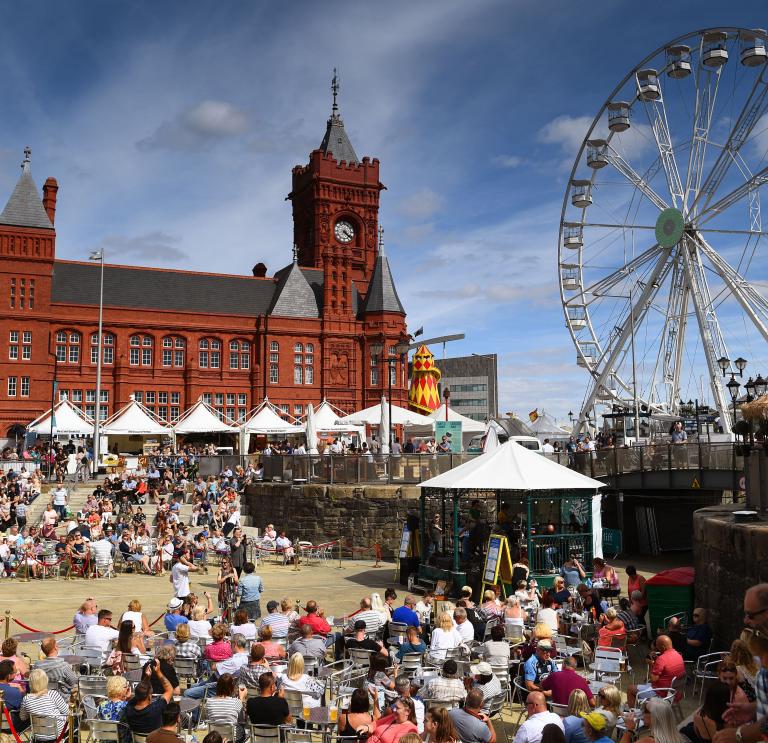 Crowds in sunny bayside area in front of Pierhead building