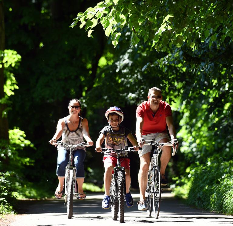 Family riding bikes along the Taff Trail, South Wales.