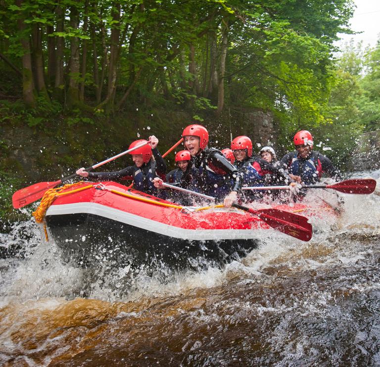 A group of people whitewater rafting down a river.
